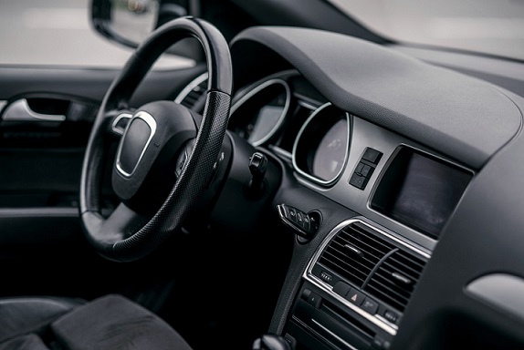 Luxury car interior. Steering wheel, shift lever and dashboard.